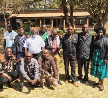 Community members meeting under a tree to discuss natural resource governance